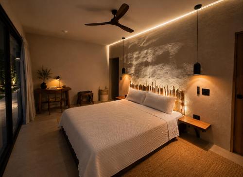 a bedroom with a white bed and a ceiling fan at Selvamar Hermosa in Playa Hermosa