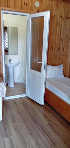 ein Schlafzimmer mit einem Bett, einem Waschbecken und einer Tür in der Unterkunft Liz - готель, сауна, ресторан in Dunaivtsi