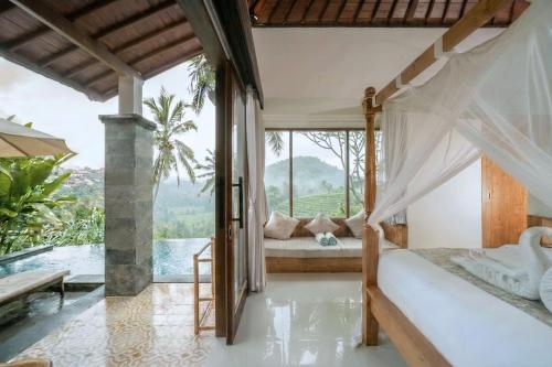 a bedroom with a bed and a view of a pool at Puri Diamond Villas in Tampaksiring
