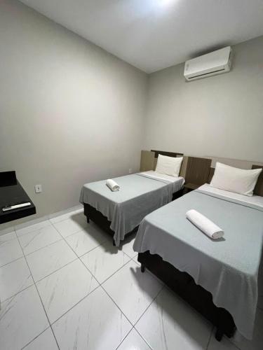 a room with two beds and a piano in it at Hotel maria araujo in Arapiraca