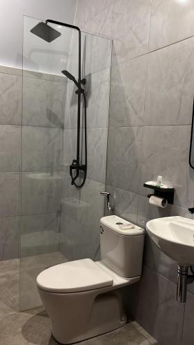 a bathroom with a shower and a toilet and a sink at Bale Rinjani Lodge & Cafe in Tetebatu