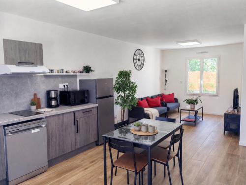 a kitchen and living room with a table and chairs at Le temps de la pause 2 in Cepoy