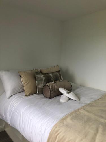 a bed with two white shoes on top of it at Luxury Glamping Cabin sleeping 4 People with Private Hot Tub and BBQ with views across the North Coast Ballycastle Pod 2 in Ballycastle