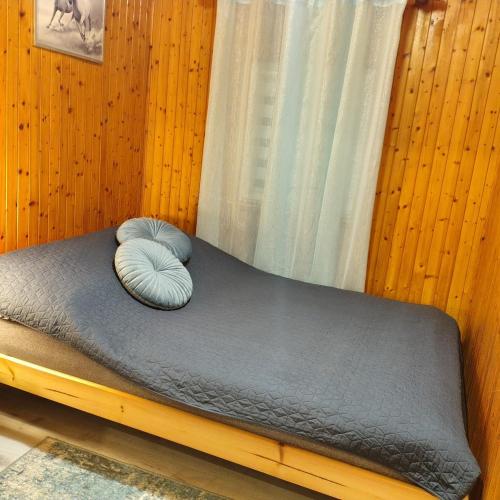 a small bed with a pillow on top of it at Domek u Prezesa in Kłótno