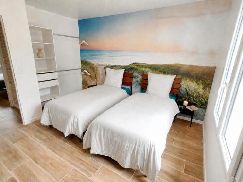 two beds in a room with a painting on the wall at Le temps de la pause 2 in Cepoy