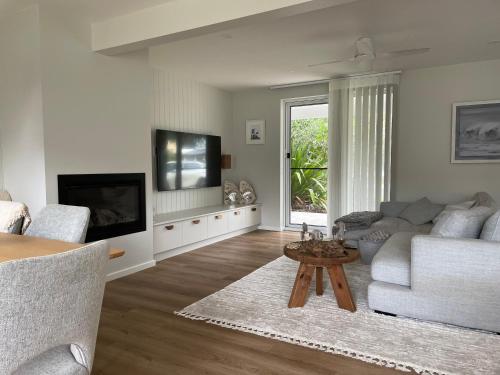 a living room with a couch and a table at Coastal Holiday House in Hawks Nest