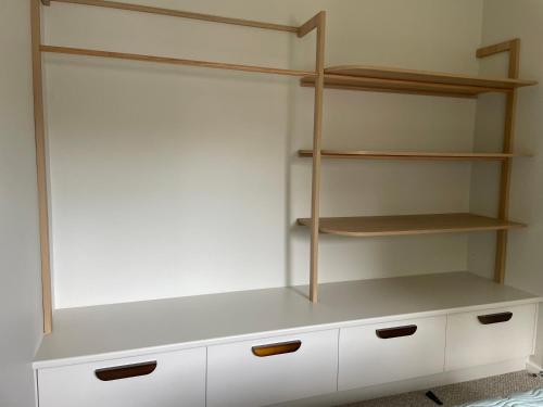 a closet with white cabinets and wooden shelves at Coastal Holiday House in Hawks Nest