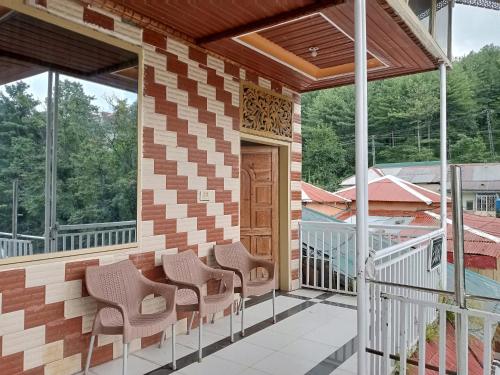 a porch of a house with chairs on it at BHURBAN view APARTMENTS in Murree