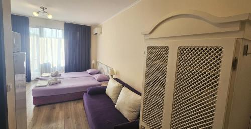 a room with a bed and a couch and a window at Sun Sea 2 in Shkorpilovtsi