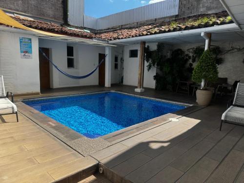 a swimming pool in a yard next to a house at Hostal Casa Verde in Santa Ana