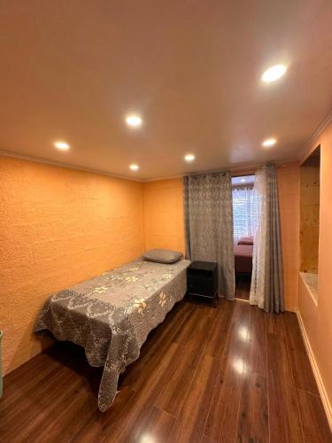 a bedroom with a bed in the corner of a room at NurHome in Mejillones