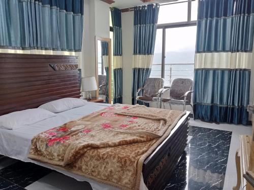 a bedroom with a bed and a large window at BHURBAN view APARTMENTS in Murree