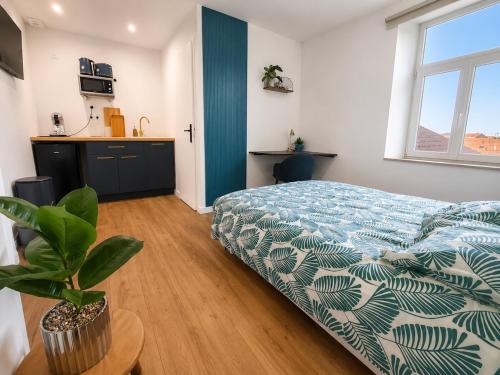 a bedroom with a bed with a blue and white comforter at Azur, Cosy Blue studio, ultra centre de Desvres in Desvres