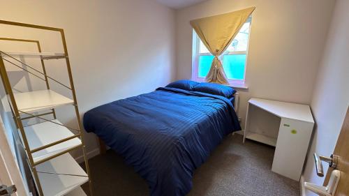 a small bedroom with a bed and a window at Modern 2 bed flat with parking by Bluewater shopping mall in Greenhithe