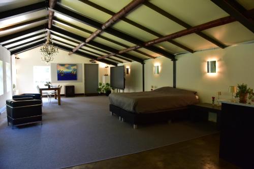 a bedroom with a bed and a table in a room at Hof van Vijfeijken in Boxtel