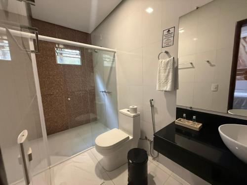 a bathroom with a toilet and a sink and a shower at Pousada Pedra Grande in Morros