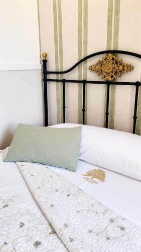a bed with a black frame and white sheets at La casita "A de Naval" in Pontevedra