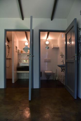 a bathroom with a sink and a toilet in a room at Hof van Vijfeijken in Boxtel