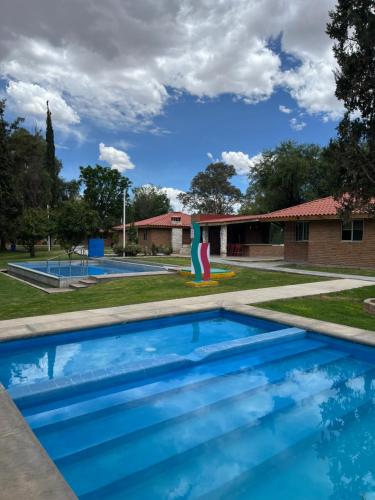 a swimming pool in a yard with a playground at Cabañas Splash Valladolid in Jesús María