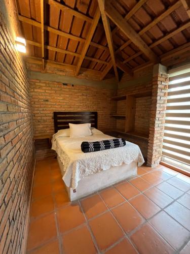 a bedroom with a bed in a brick wall at Cabañas Splash Valladolid in Jesús María