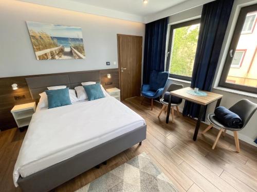 a bedroom with a bed and a desk and a chair at Villa Continental in Pobierowo