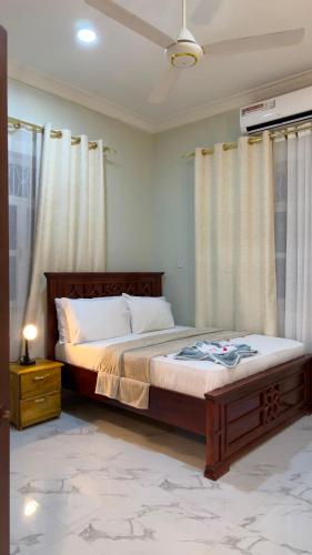 a bedroom with a bed with a wooden frame and curtains at Shanayah house in Zanzibar City