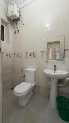 a white bathroom with a toilet and a sink at Shanayah house in Zanzibar City
