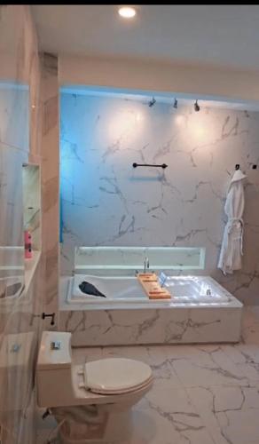 a bathroom with a tub and a toilet and a sink at takara stay in Delmas