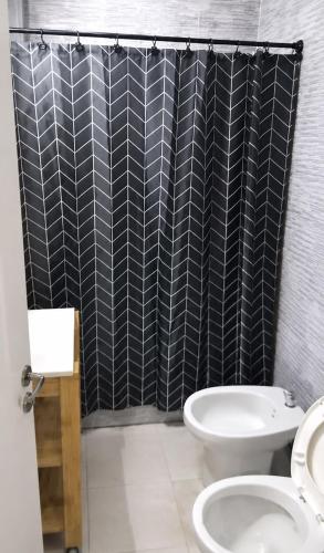 a bathroom with a toilet and a black shower curtain at Aires Express in Buenos Aires