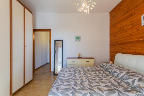 a bedroom with a bed and a wooden wall at Dimora Levante - Pool & Tennis in Noicattaro