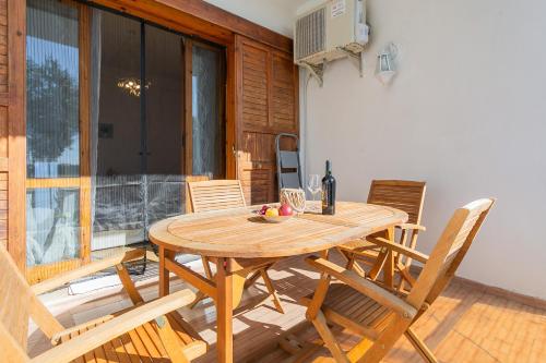 a wooden table with chairs and a bottle of wine at Dimora Levante - Pool & Tennis in Noicattaro