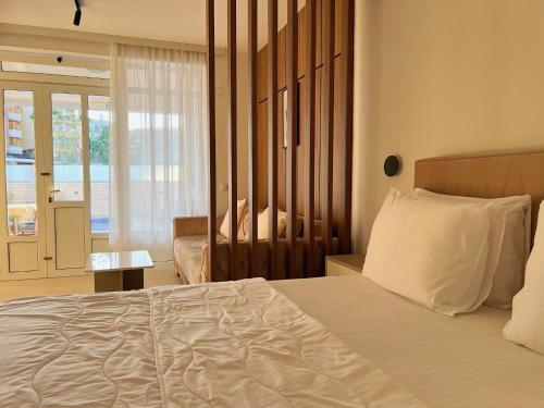 a bedroom with a large white bed and a window at Apartments Fat e Jet - Pool & Breakfast in Ulcinj