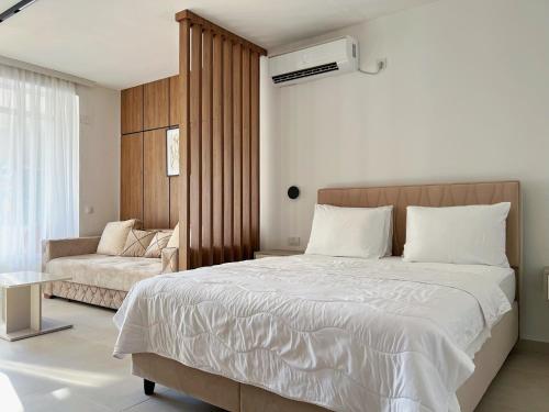 a bedroom with a large bed and a couch at Apartments Fat e Jet - Pool & Breakfast in Ulcinj