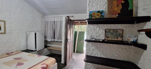 a kitchen with a refrigerator in a room at Pousada Tia Lucia in Saquarema