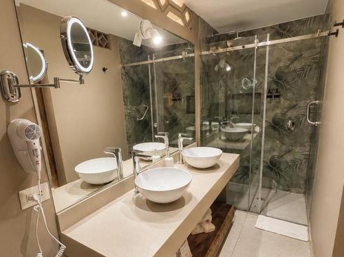 a bathroom with three sinks and a shower at Hotel Sol de Ica in Ica