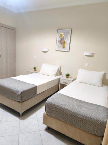 two beds in a hotel room with two beds at Vicky's Guesthouse in Kavos
