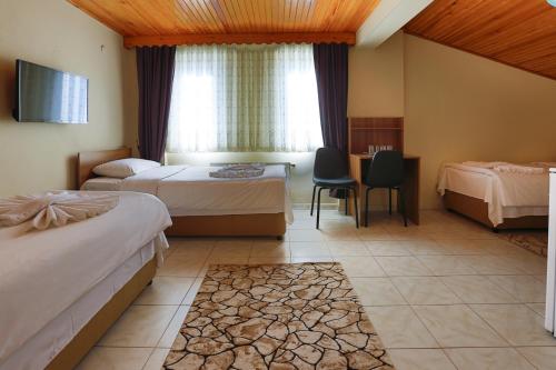 チャナッカレにあるGizem Pansiyonのベッド2台と窓が備わるホテルルームです。