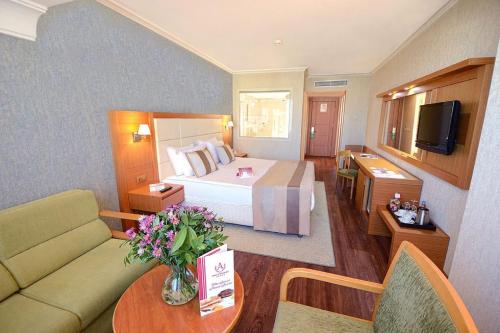 ein Hotelzimmer mit einem Bett und einer Couch in der Unterkunft Insfra Hotel in Khatīma
