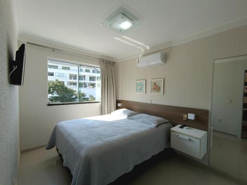 a bedroom with a bed and a window at Bombinhas Summer Beach in Bombinhas