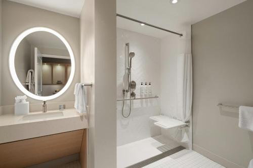 a bathroom with a shower and a sink and a mirror at TownePlace Suites by Marriott Seekonk in Seekonk