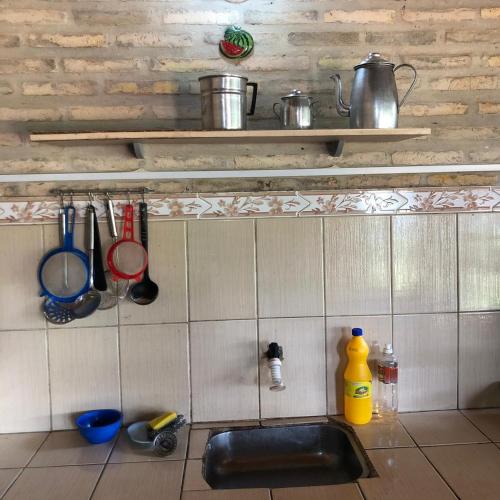 a kitchen counter with a sink and utensils on a wall at La Soñada in Coronel Martínez