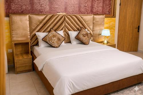 a bedroom with a large white bed with pillows at Airport Side Hotel in Accra