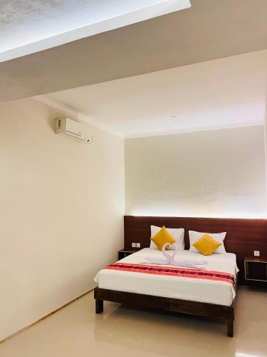 a bedroom with a large bed with yellow pillows at WLA Homestay in Labuan Bajo