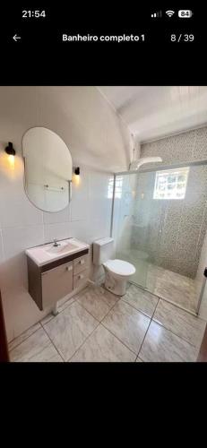 a bathroom with a shower and a sink and a toilet at Chacara Recanto Mirella in Socorro