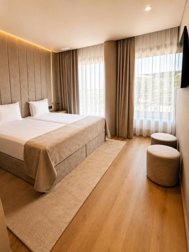 a bedroom with a large bed and a large window at INOTEL Paços de Ferreira in Paços de Ferreira
