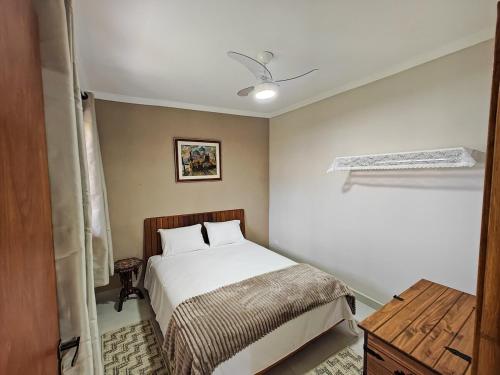 a small bedroom with a bed and a table at Cura e Conexões in Jarinu
