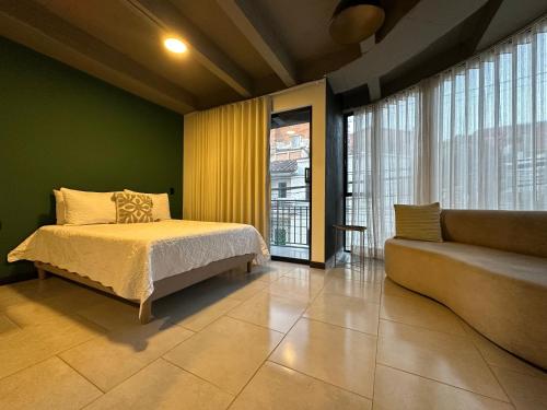 a bedroom with a bed and a couch at Hotel Moore 45 in Medellín