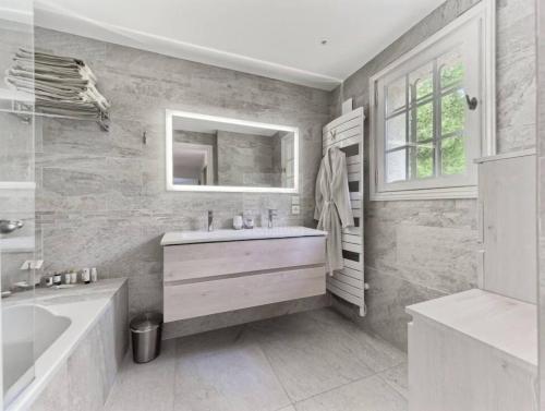 a bathroom with a sink and a tub and a mirror at Havre de paix -Élégante villa avec piscine au cœur d'un écrin de verdure in Vence