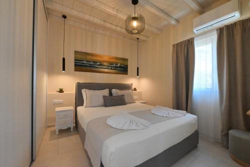 a bedroom with a large white bed with two pillows at Horizon Hill Villa in Tinos