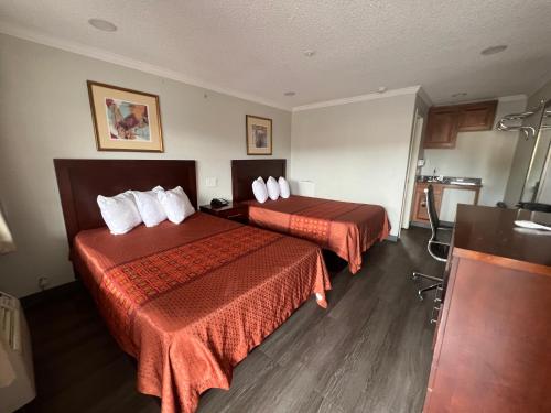 a hotel room with two beds with red sheets at Golden Eagle Motel in Dorris